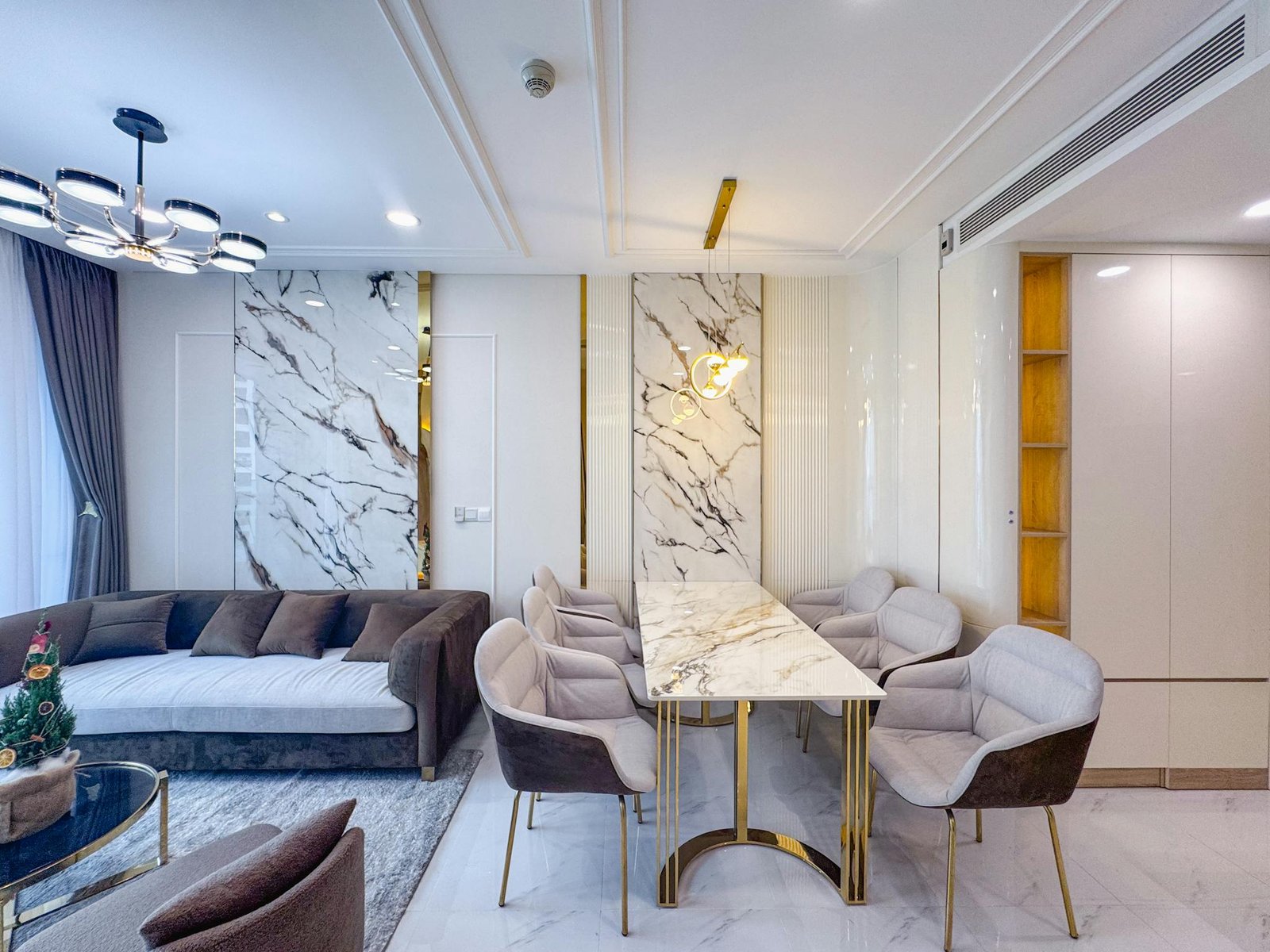 Luxurious living and dining room with marble decor and contemporary furniture.